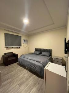 麦加Al-mohamdiah apartments的卧室配有床和大屏幕