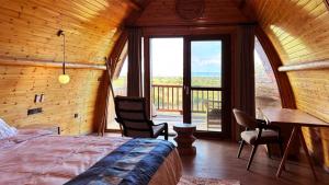 塞伦盖蒂国家公园Serengeti Ark Safari Lodge - Kogatende的一间卧室配有一张床铺和一张桌子,并设有一个阳台
