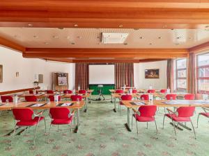 巴特迪克海姆巴特迪克海姆美居酒店的教室里配有桌子和红色椅子