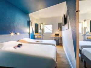 布里地区叙西布里地区叙西宜必思快捷酒店 的蓝色墙壁客房的两张床