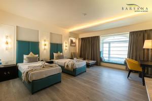 西里古里Barsana Hotel & Resort Siliguri的酒店客房配有两张床和一张书桌