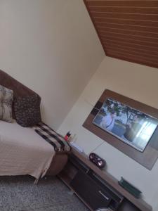 索科罗Chácara pedacinho do céu的卧室配有一张床,墙上配有电视。