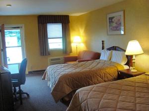 New BerlinvilleBudget Host Inn的酒店客房配有两张床和一张书桌