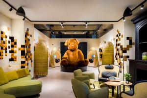 波尔多FirstName Bordeaux by Hyatt的坐在房间中间的大泰迪熊