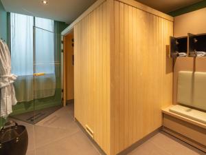 安锡Le Splendid Hotel Lac D'Annecy - Handwritten Collection的一间带木墙和玻璃淋浴间的浴室