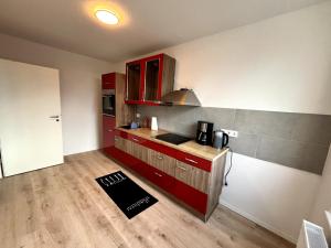 Soleblick的铺有木地板的厨房配有红色橱柜