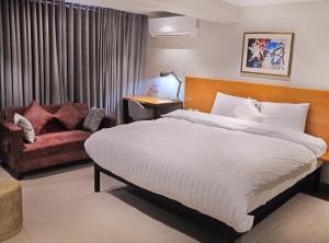 伊斯兰堡The Avenue Hotel的一间卧室配有一张大床和一张沙发