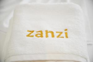 都拉斯Hotel Zanzi的白色毛巾,上面写有沙尔马字