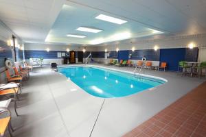 尚佩恩Holiday Inn Champaign, an IHG Hotel的一个带桌椅的房间的大型游泳池
