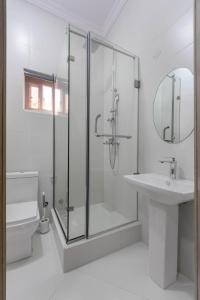 拉各斯Firenze Apartments Lekki的带淋浴和盥洗盆的白色浴室