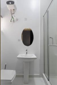 拉各斯Firenze Apartments Lekki的白色的浴室设有水槽和镜子