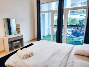 阿布扎比Harf-G13 Fancy 1BR w big balcony at Ansam , Yas Island的一间卧室配有一张大床和两条毛巾