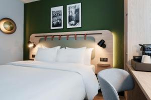 巴黎钟楼巴黎19维耶特酒店的卧室配有白色的床和椅子