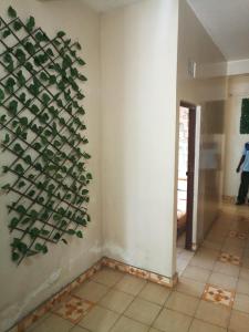 基苏木Mona Lisa Guest House, Kisumu的墙上有植物的房间