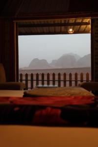 瓦迪拉姆Wadi Rum Relaxation Camp的一间卧室设有一张床和一个大窗户
