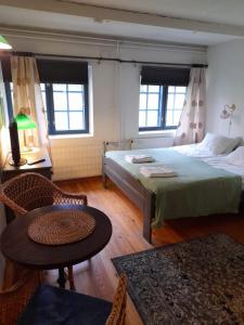 维塔萨里Wiikki Majatalo的一间卧室配有一张床、一张桌子和两个窗户