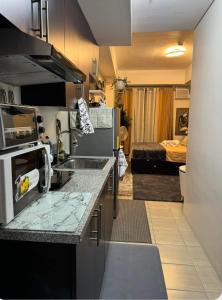马尼拉Flexi-Living Premium Condo in Kasara的带水槽的厨房和1间带床的房间
