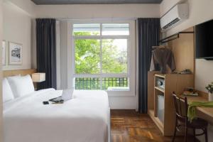 曼谷Ago Hotel Chinatown的酒店客房设有床和窗户。