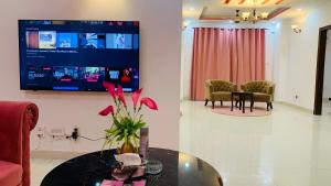 伊斯兰堡Serene Home Apartment (1-Bedroom)的客厅配有玻璃桌和电视