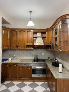 都拉斯LuxurySeaview Apartment的厨房配有木制橱柜和炉灶烤箱。