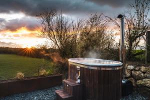 帕兹托Bogee Farm的花园内的热水浴池,享有日落美景