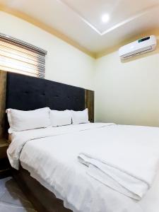 RubuchiCome Inn Hotel的一间卧室配有一张带白色床单的大床