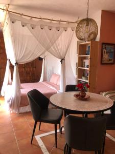 阿尔姆尼卡Cortijo el Abejaruco的卧室配有一张床和一张桌子及椅子