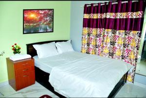 奇克马格尔Royal Guest House的一间卧室配有两张床、窗帘和梳妆台。