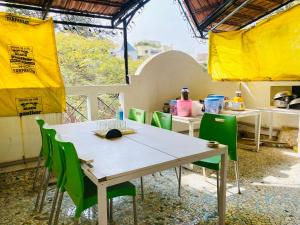 浦那Budget Private Ac Room with Kitchen Near Osho Garden的一张桌子和一张绿色椅子