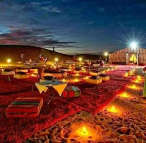 梅尔祖卡Merzouga luxurious Camps的一群太阳伞在晚上在海滩上