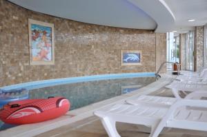 库萨达斯Lavender Residence的一个带白色椅子和红色木筏的游泳池
