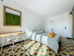 马赛Appartement 8 Couchages - Central & Spacieux - Les Frères de la Loc'的一间卧室配有一张床、一张桌子和一把椅子