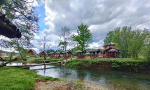 ZolaćiBungalow Fly Fishing Kljuc River Sanica的河边的一群房子