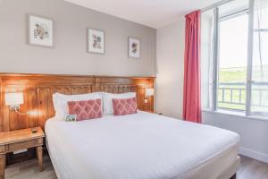 卡纳克Hotel Restaurant Spa du Tumulus Carnac的一间卧室设有一张大床和一个窗户。
