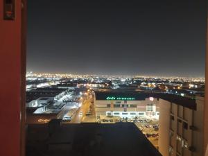 沙迦Family Room In Sharjah的建筑在晚上可欣赏到城市美景