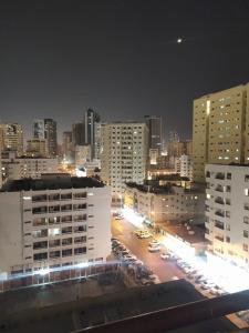 沙迦Family Room In Sharjah的夜间停车的城市