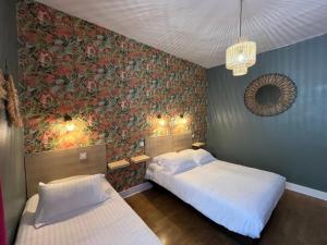 勒比格Logis Hôtel Le Cygne的一间卧室配有两张床和壁画