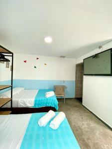 布卡拉曼加Hotel Anauco的一间卧室配有两张床和一台平面电视