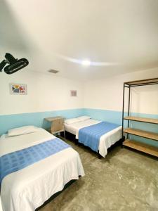 布卡拉曼加Hotel Anauco的蓝色墙壁客房的两张床