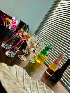 赫特福德HOME Hertford的桌子上放有玻璃杯和瓶装葡萄酒