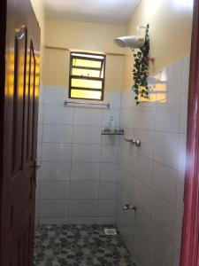 基苏木Kisumu Airview Homestay的浴室设有白色瓷砖和窗户。