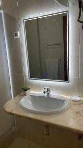 普拉亚Felicidade Hotel的浴室水槽和上面的大镜子