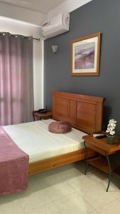 普拉亚Felicidade Hotel的一间卧室配有床、床头柜和一张四柱床