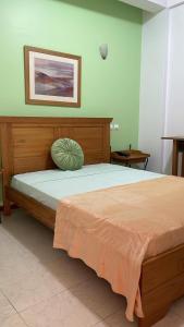 普拉亚Felicidade Hotel的一间卧室配有一张大床和木制床头板