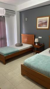普拉亚Felicidade Hotel的一间卧室设有两张床和一张桌子上的台灯。