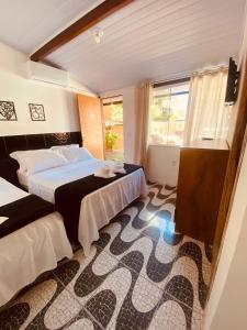 里约达欧特拉斯Residencial Costa Mar的酒店客房设有两张床和窗户。