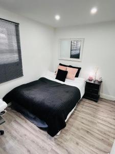 赫特福德HOME Hertford的一间卧室配有一张带黑色床单和粉红色枕头的床。