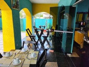 瓜鲁雅Pousada Sereia Tropical的用餐室配有桌椅