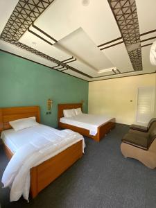 锡卡都Apricot Spring Resort的一间卧室配有两张床和椅子