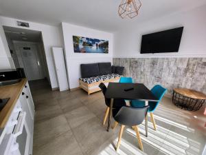 索托德拉马里纳Apartamentos Playa De Covachos的厨房以及带桌椅的起居室。